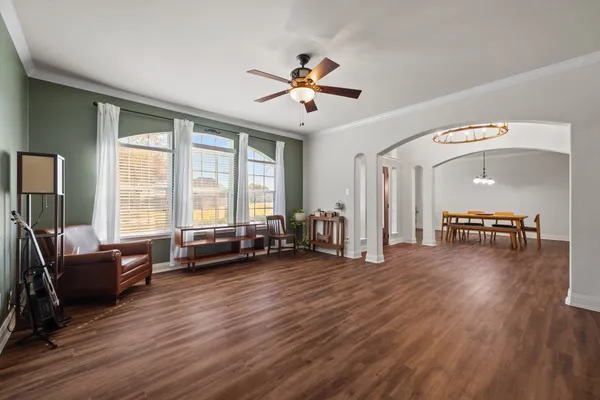 a living room with furniture and three large window