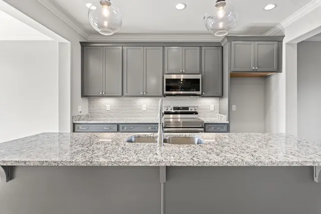 a kitchen with stainless steel appliances granite countertop a sink a stove and a refrigerator