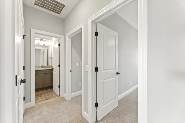 a view of a hallway with closet and wooden floor