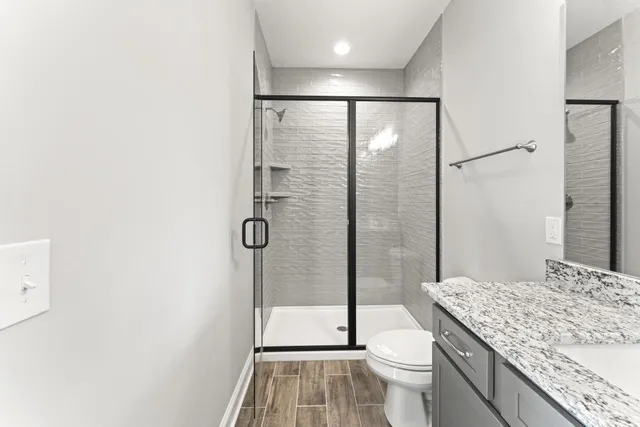 a bathroom with a granite countertop sink toilet and shower