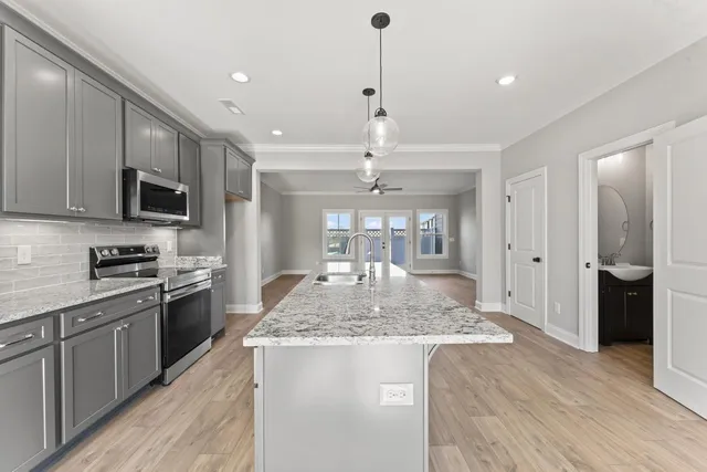 a kitchen with stainless steel appliances granite countertop a sink stove and refrigerator