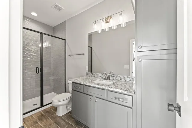 a bathroom with a granite countertop sink toilet and shower