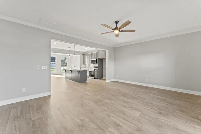 a view of a livingroom with a furniture wooden floor and a ceiling fan