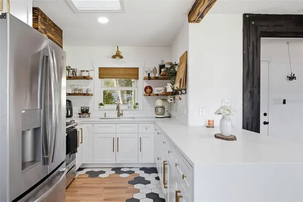 a kitchen with stainless steel appliances granite countertop a sink dishwasher stove and wooden floor