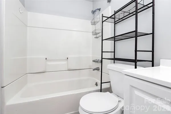 a bathroom with a white toilet and a bath tub