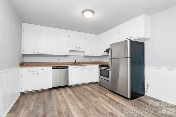a kitchen with a refrigerator sink and cabinets