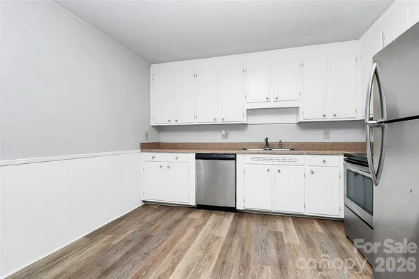 a kitchen with granite countertop white cabinets and white appliances