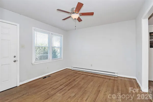 an empty room with a window and a ceiling fan