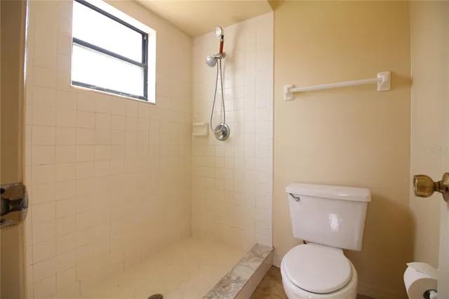 a white toilet sitting next to a shower