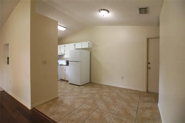 a view of a storage & utility room with refrigerator