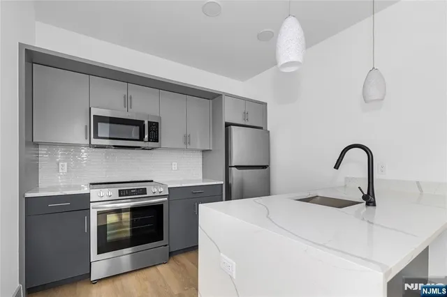 a kitchen with stainless steel appliances a stove microwave and sink