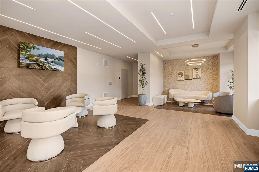 1435 10th Street, Unit 208 Fort Lee, NJ 07024 - Photo 22 of 23 a living room with furniture and a wooden floor