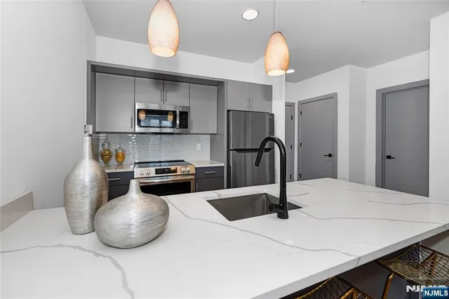 a kitchen with a sink a stove and cabinets