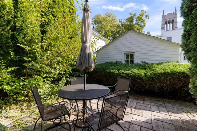 a backyard with table and chairs and potted plants