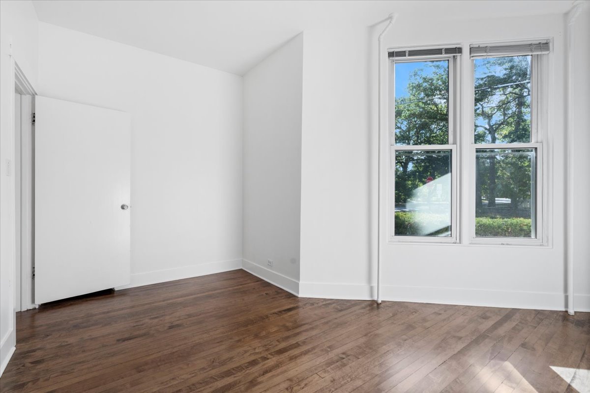 1097 Tower Road, Unit A Winnetka, IL 60093 - Photo 8 of 17 a view of an empty room with wooden floor and a window