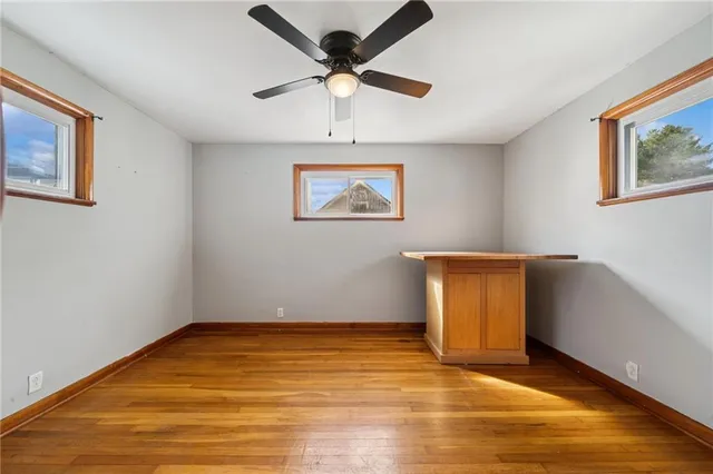 a view of an empty room with window and wooden floor