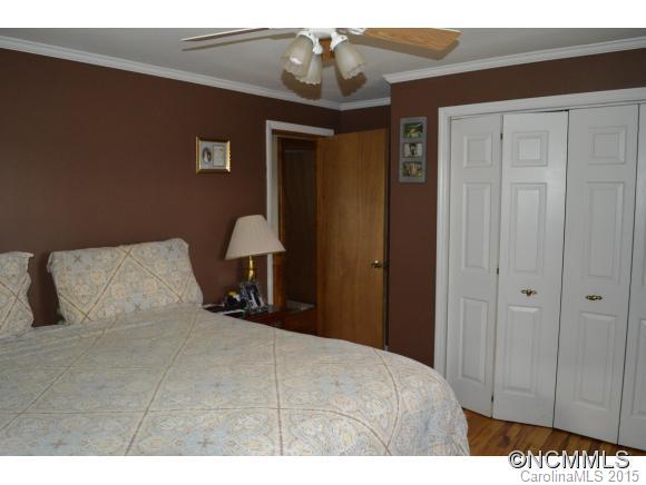 329 Ridgedale Road Clyde, NC 28721 - Photo 13 of 22 a bedroom with a bed and a chandelier
