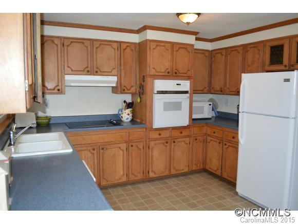 329 Ridgedale Road Clyde, NC 28721 - Photo 17 of 22 a kitchen with stainless steel appliances granite countertop a refrigerator a sink and white cabinets