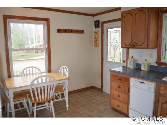 329 Ridgedale Road Clyde, NC 28721 - Photo 22 of 22 a kitchen with granite countertop wooden cabinets a dining table and chairs