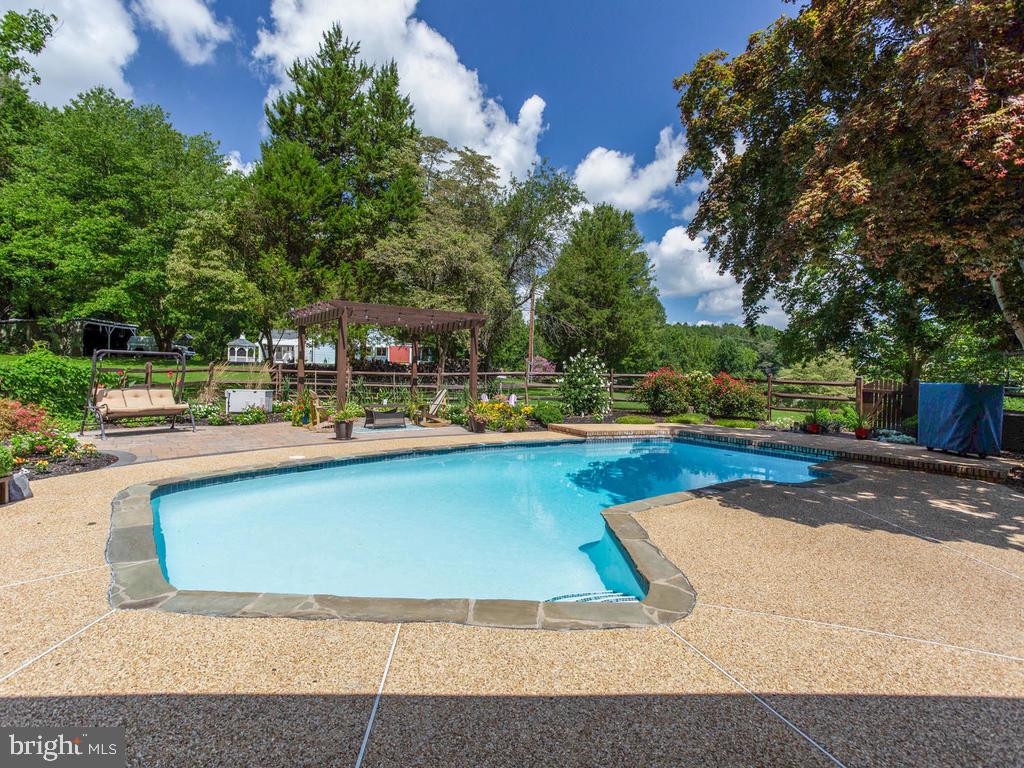 6678 Old Solomons Island Road Friendship, MD 20758 - Photo 1 of 57 a view of swimming pool with outdoor seating and trees in the background