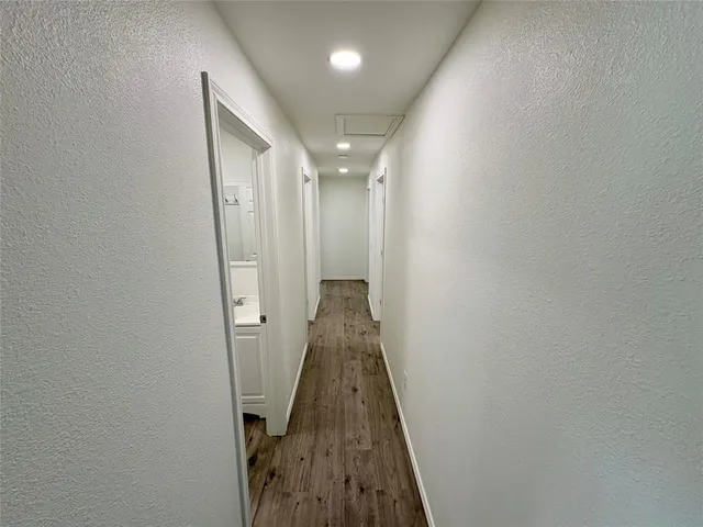 a view of a hallway with wooden floor