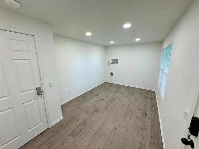 an empty room with wooden floor and entrance