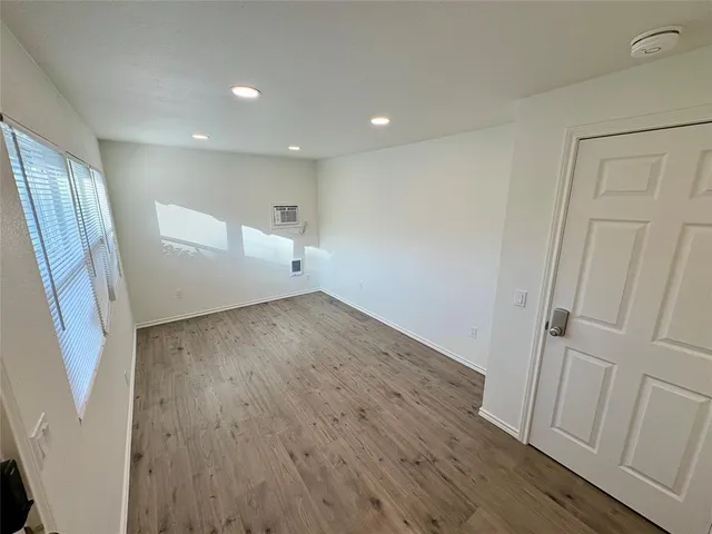 an empty room with wooden floor and entrance