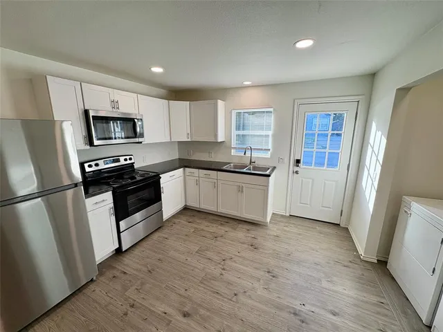 a kitchen with white cabinets and stainless steel appliances