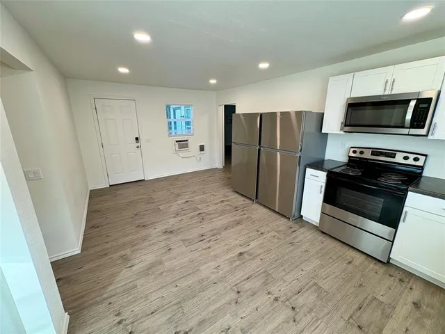 a view of kitchen with refrigerator stove and wooden cabinets