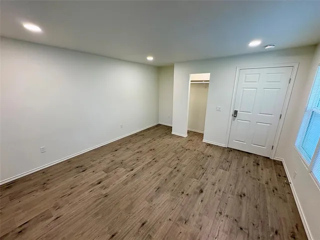 an empty room with wooden floor and closet