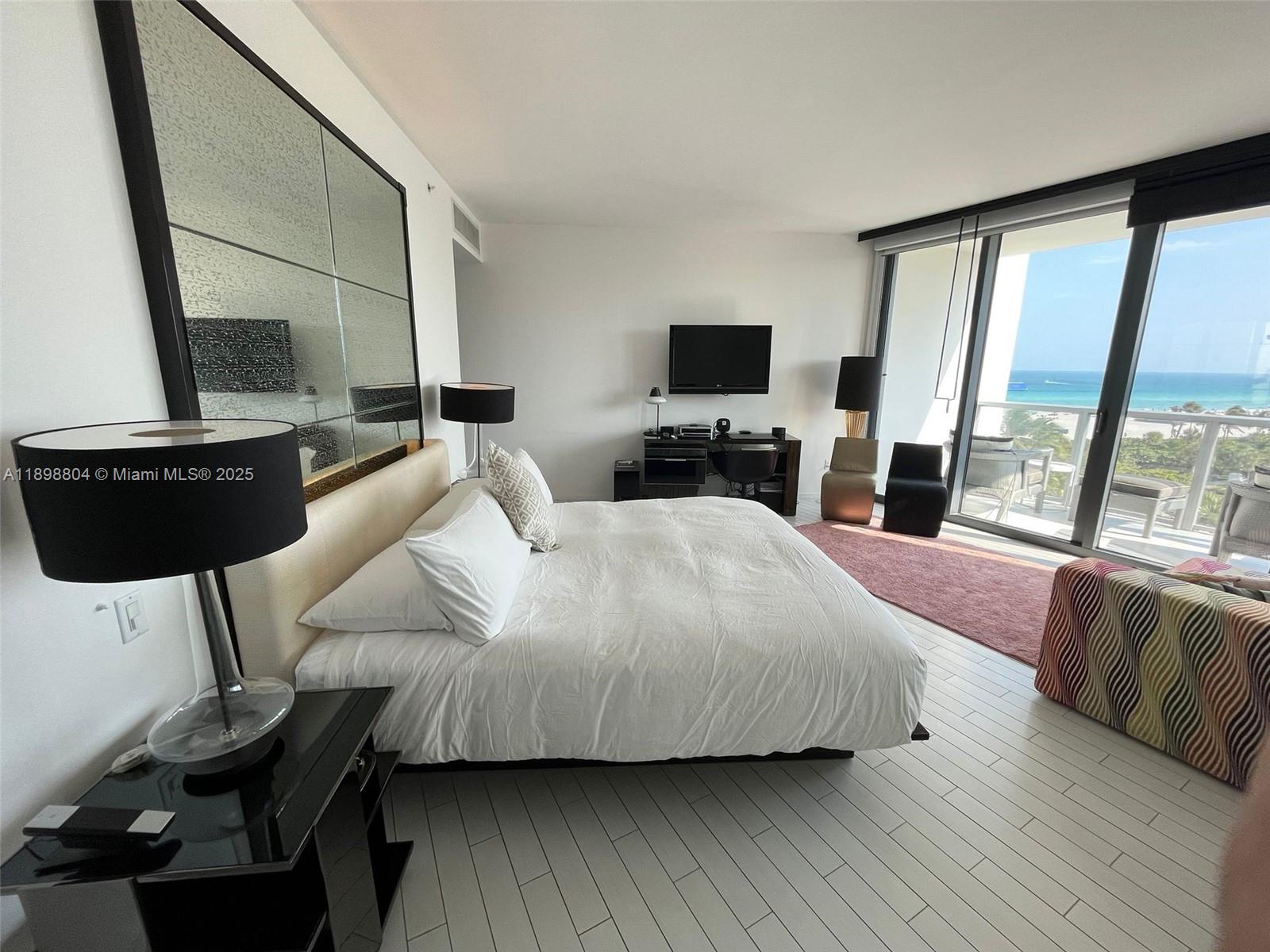 2201 Collins Avenue, Unit 626 Miami Beach, FL 33139 - Photo 2 of 12 a bedroom with a bed a couch and large window