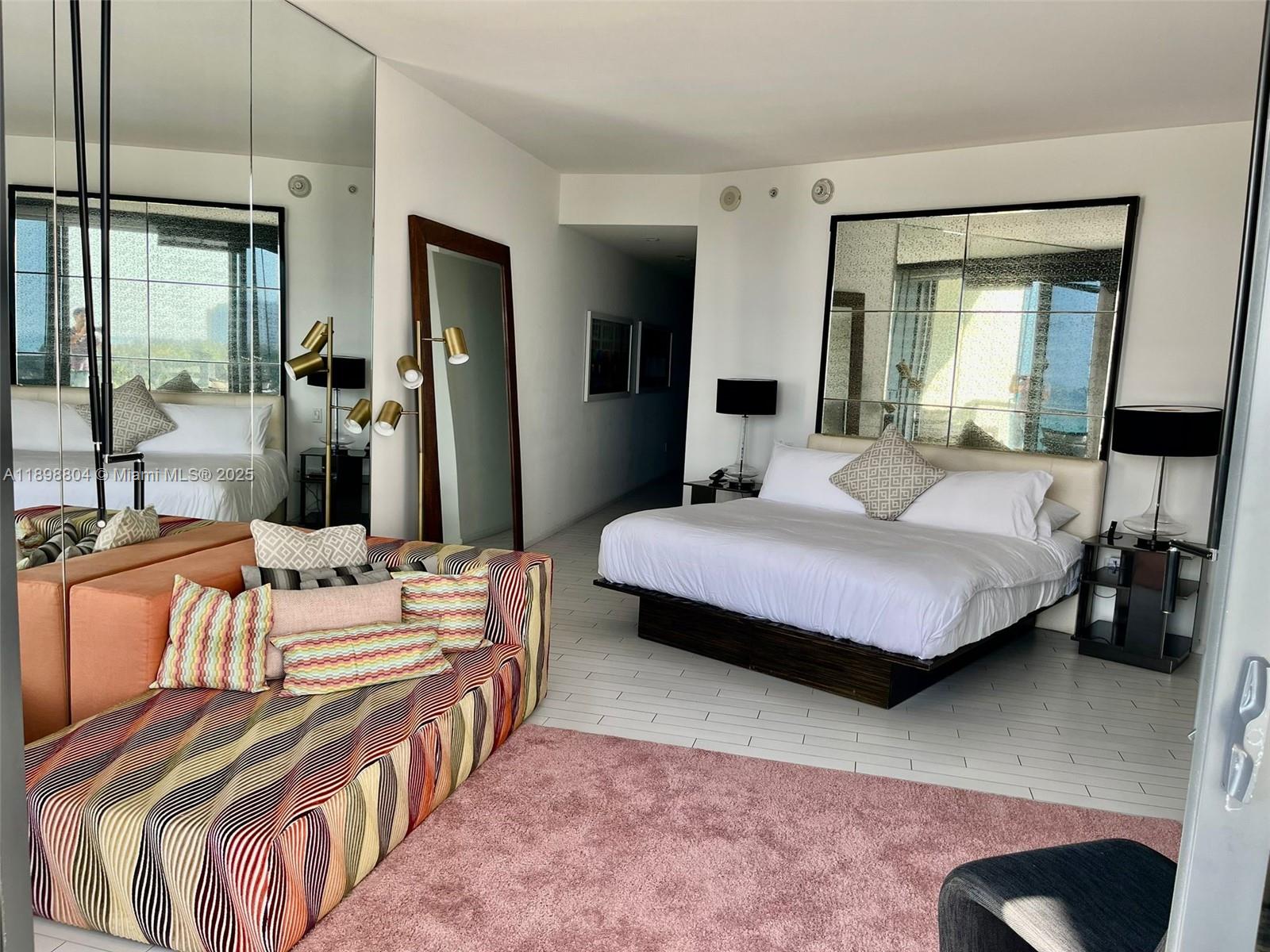 2201 Collins Avenue, Unit 626 Miami Beach, FL 33139 - Photo 7 of 12 a bedroom with a bed a table and large mirror