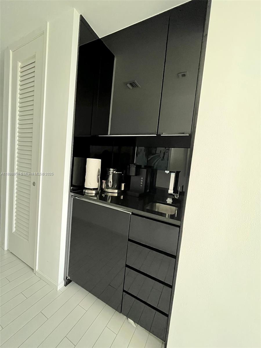 2201 Collins Avenue, Unit 626 Miami Beach, FL 33139 - Photo 8 of 12 a kitchen with a refrigerator and cabinets
