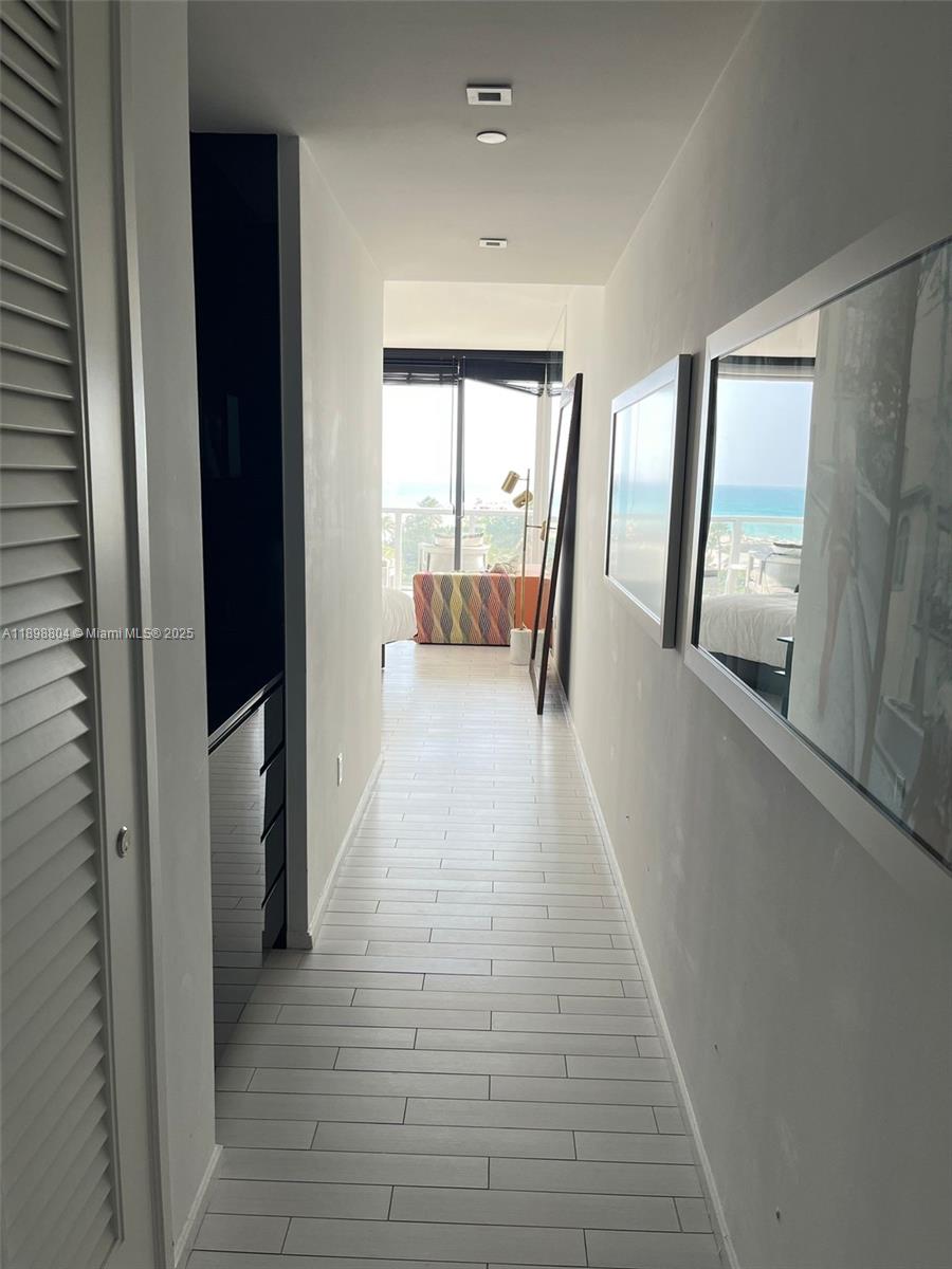 2201 Collins Avenue, Unit 626 Miami Beach, FL 33139 - Photo 9 of 12 a hallway with a large window and couch