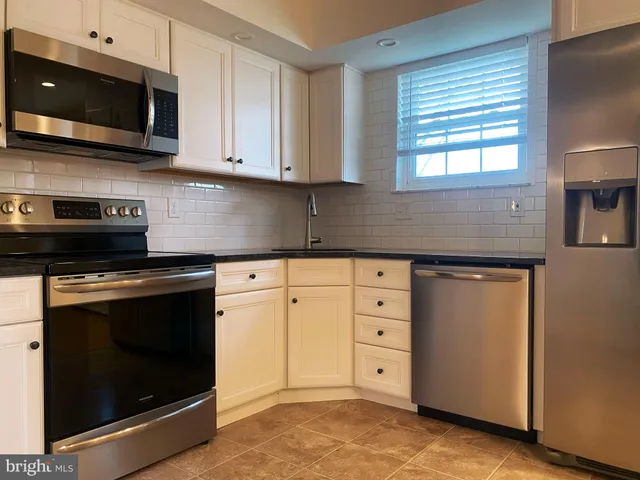 a kitchen with granite countertop white cabinets stainless steel appliances and sink