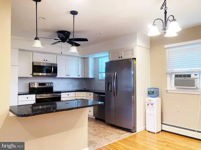 a kitchen with stainless steel appliances granite countertop a refrigerator a sink and a stove