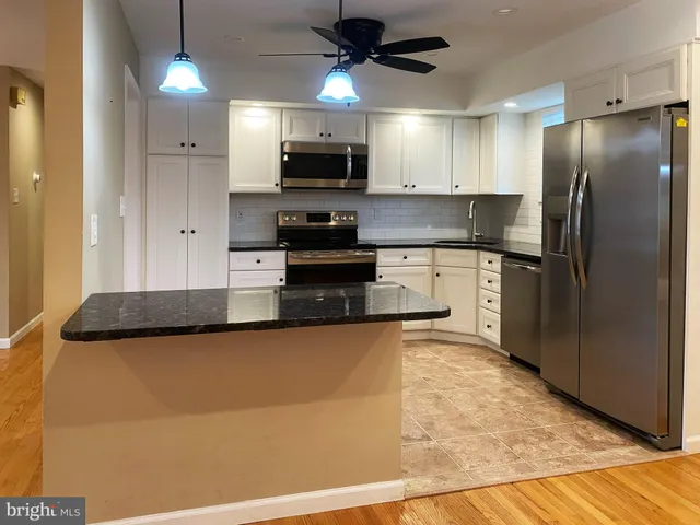 a kitchen with stainless steel appliances granite countertop a refrigerator a stove top oven a sink and dishwasher