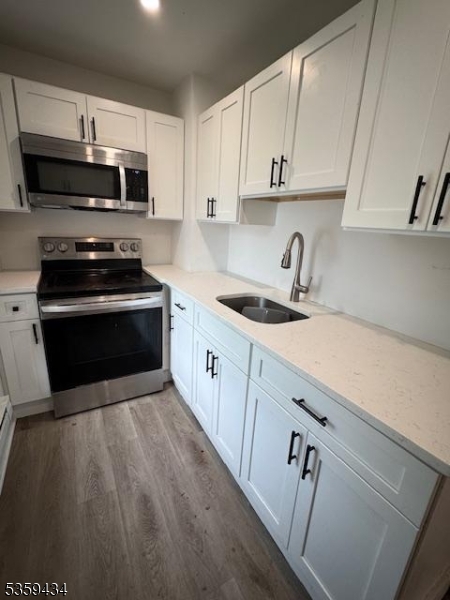 252 Spring Street Newton, NJ 07860 - Photo 2 of 18 a kitchen with granite countertop a sink a stove top oven and cabinetry