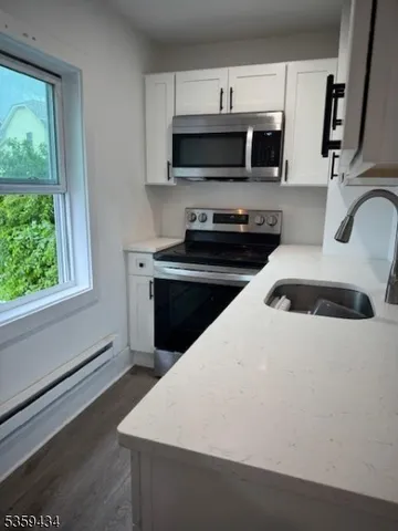 a kitchen with a sink a stove and microwave