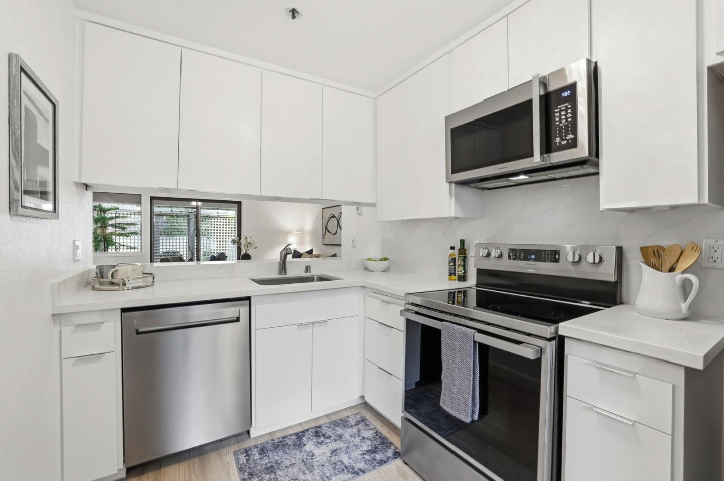 449 Alberto Way, Unit 132 Los Gatos, CA 95032 - Photo 11 of 42 a kitchen with stainless steel appliances granite countertop a sink and a stove top oven