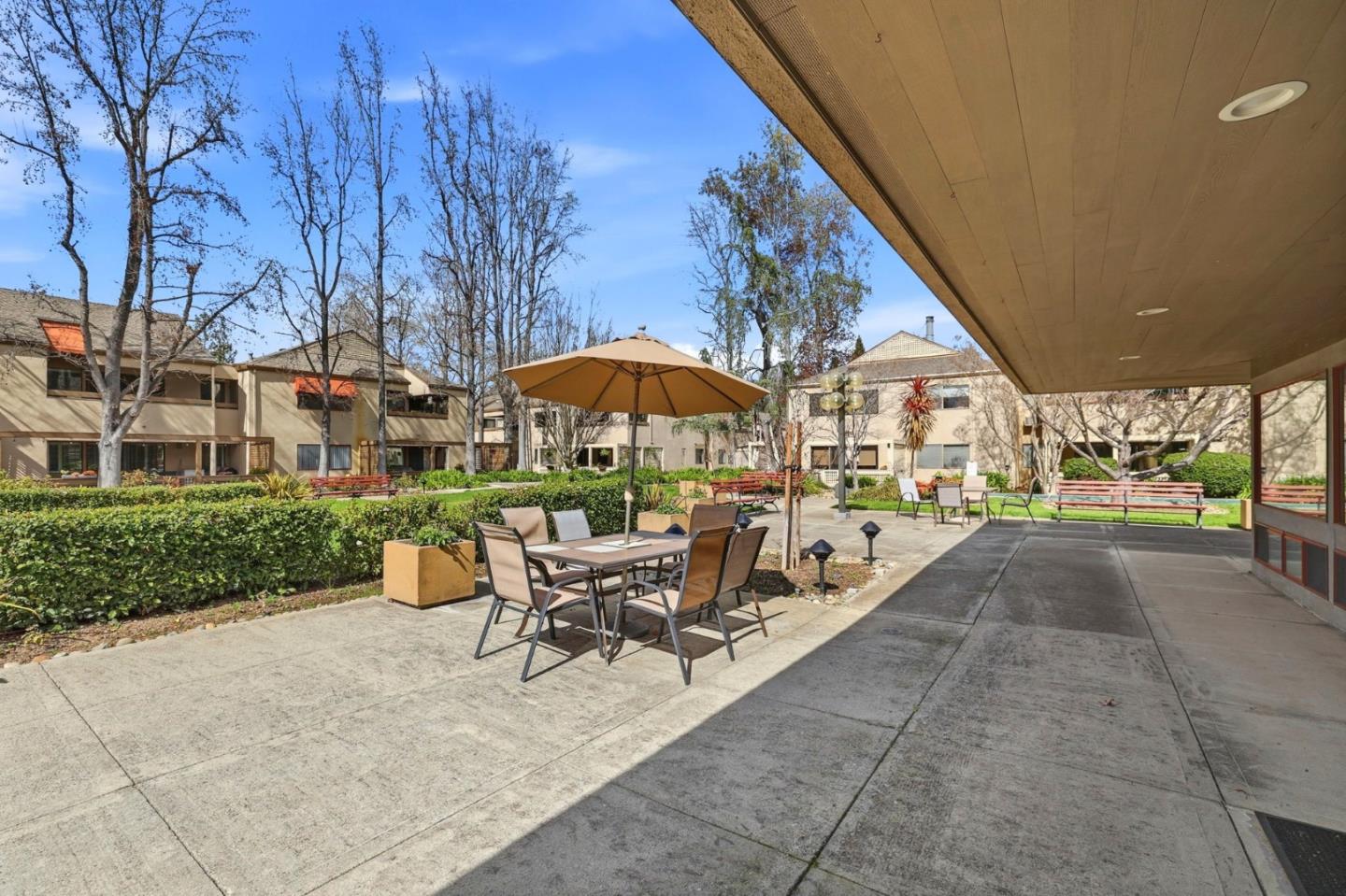 449 Alberto Way, Unit 132 Los Gatos, CA 95032 - Photo 31 of 42 a view of a patio with a table and chairs under an umbrella