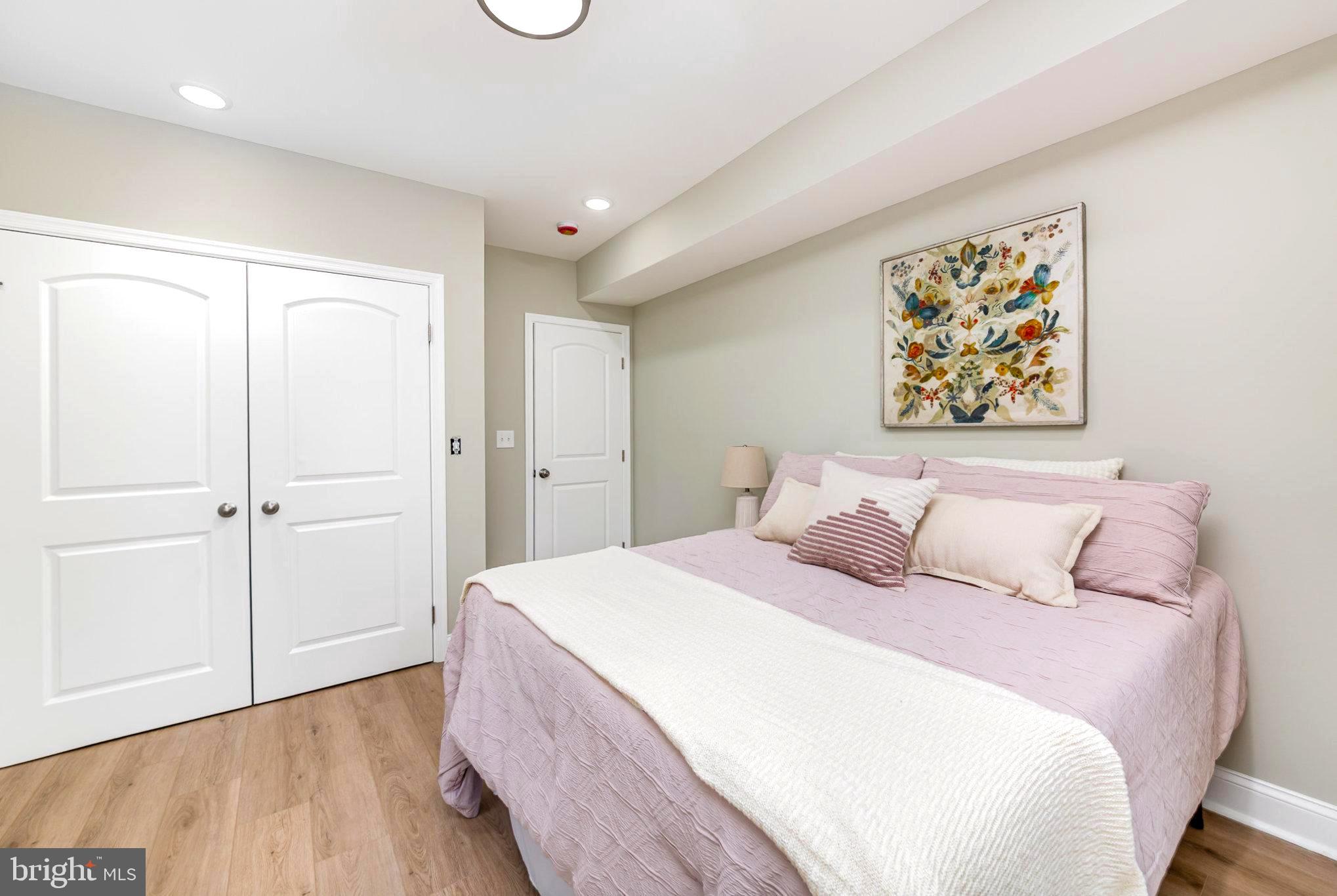 5611 Pilgrim Road Baltimore, MD 21214 - Photo 11 of 35 a spacious bedroom with a bed and a painting on the wall