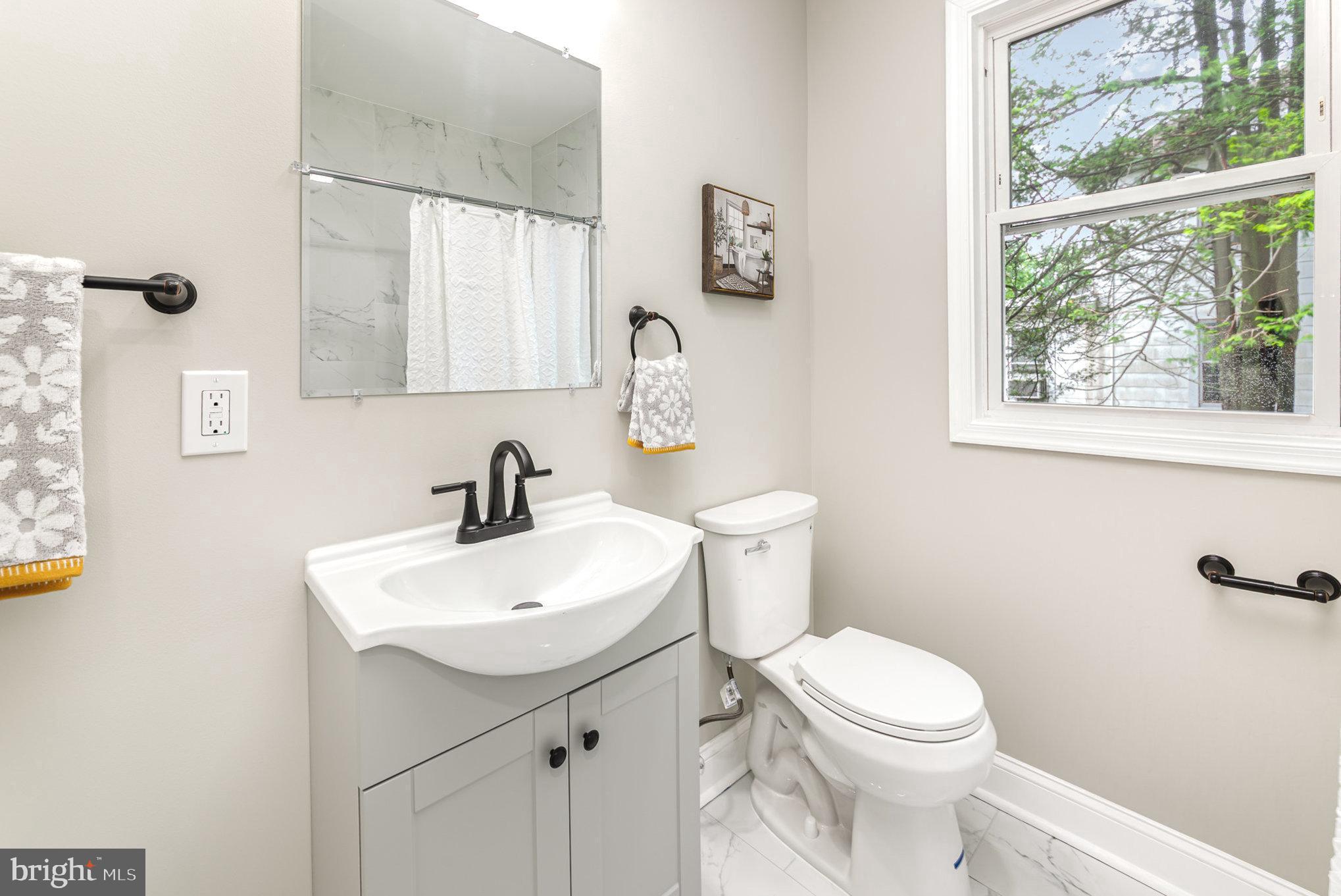 5611 Pilgrim Road Baltimore, MD 21214 - Photo 13 of 35 a white toilet sitting next to a bathroom sink