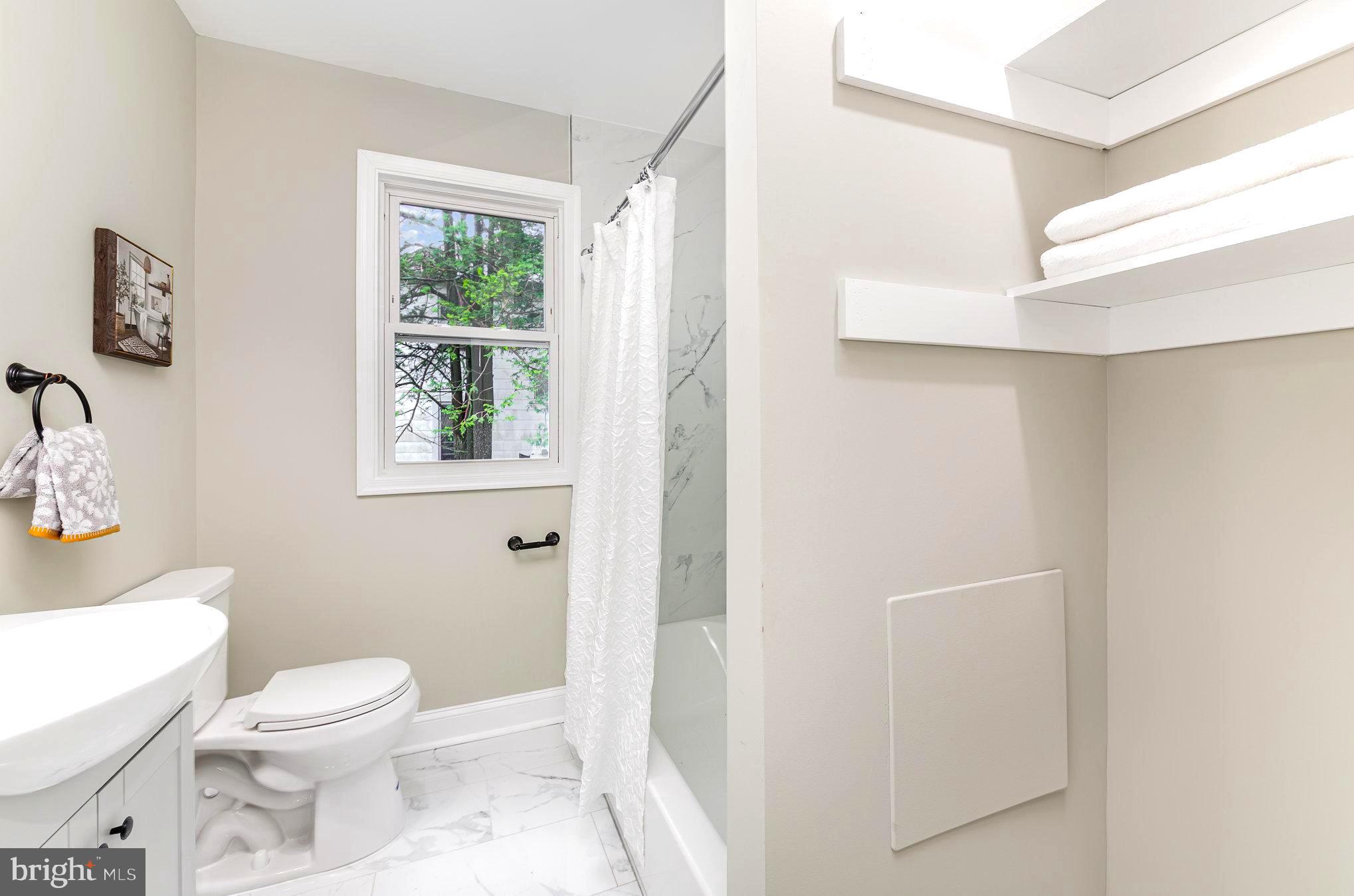 5611 Pilgrim Road Baltimore, MD 21214 - Photo 14 of 35 a bathroom with a toilet a sink and a window