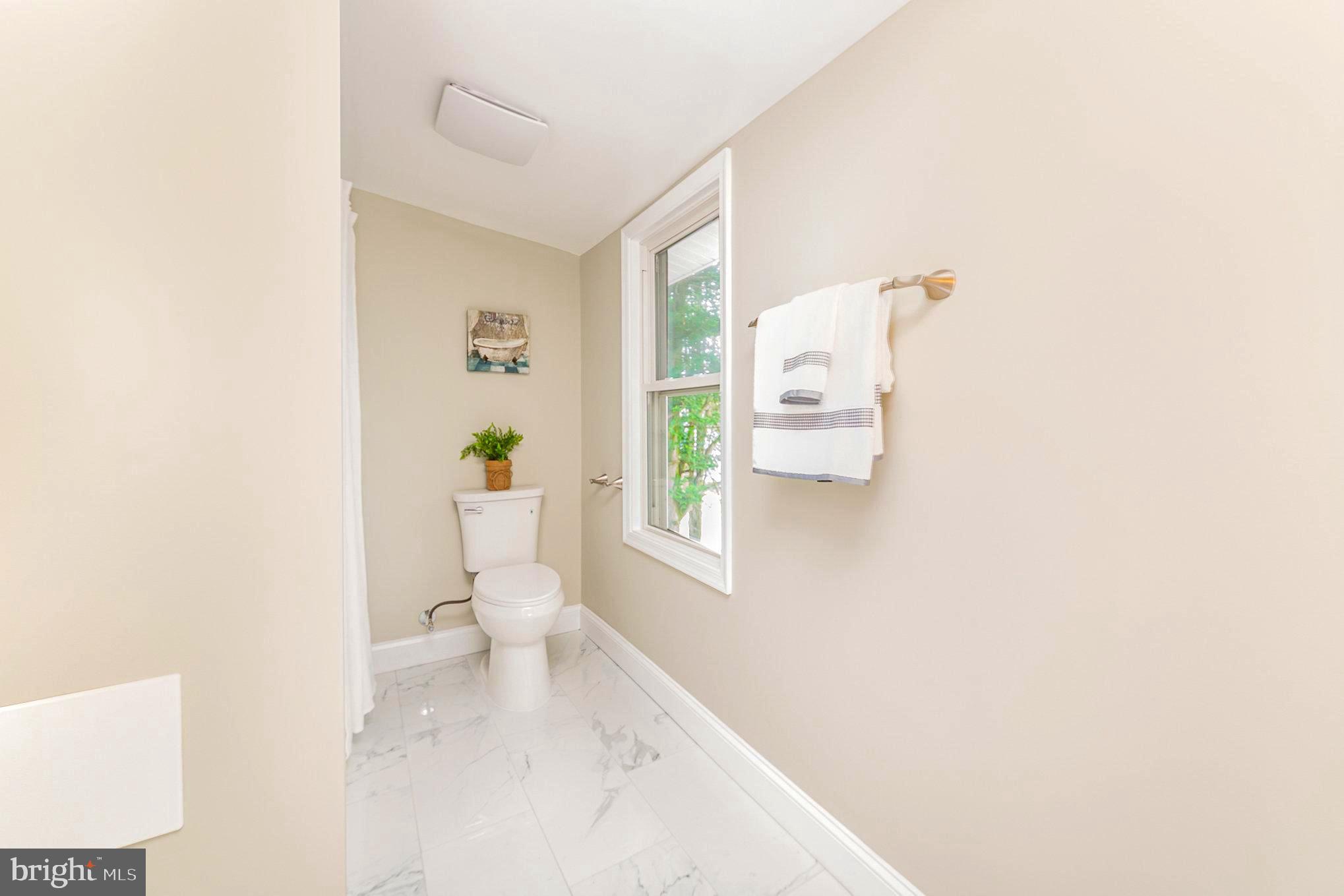 5611 Pilgrim Road Baltimore, MD 21214 - Photo 18 of 35 a white toilet sitting next to a bathroom sink