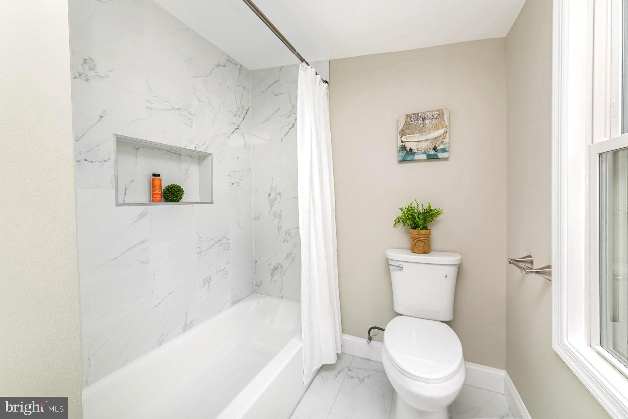 5611 Pilgrim Road Baltimore, MD 21214 - Photo 19 of 35 a white toilet sitting next to a bath tub