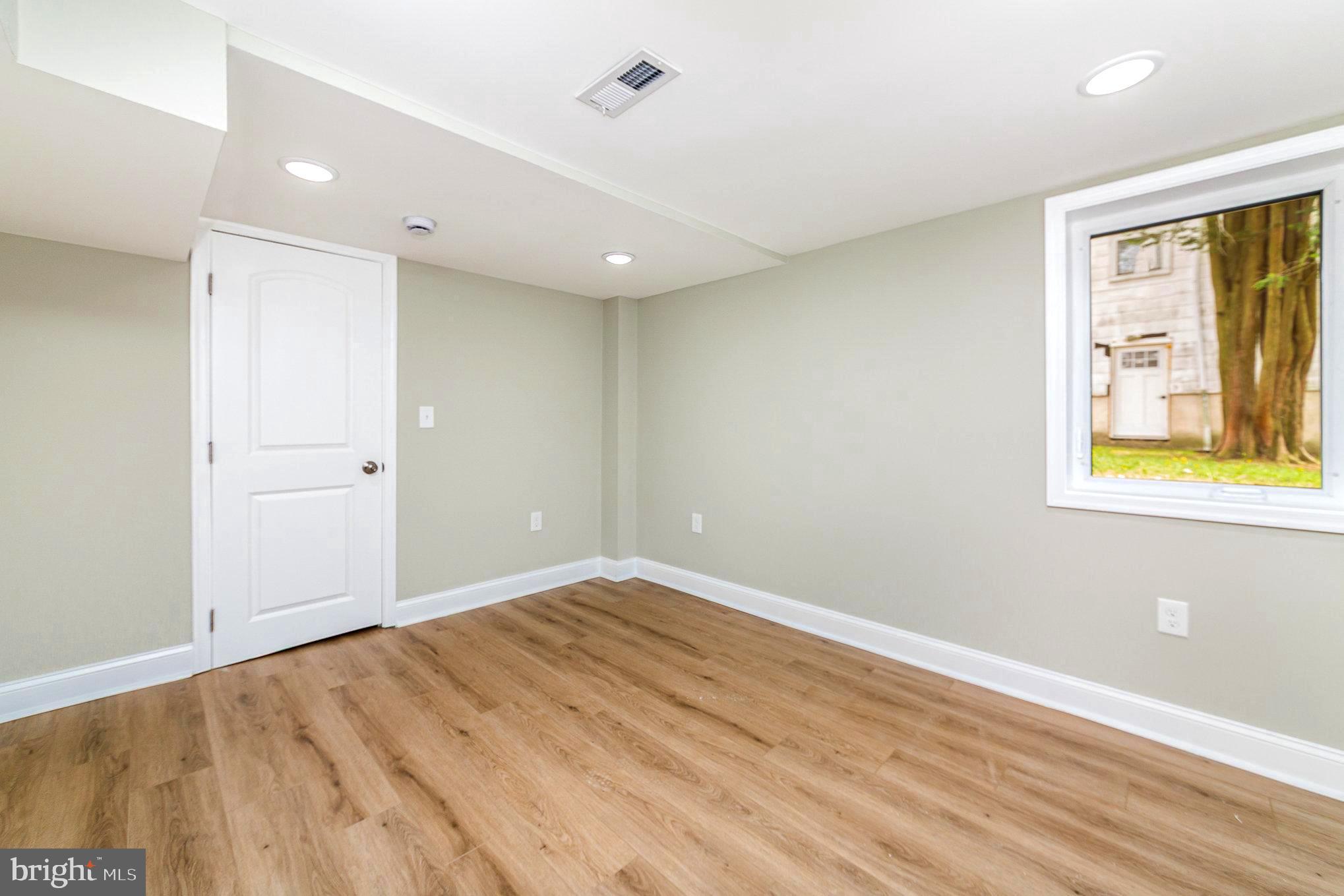 5611 Pilgrim Road Baltimore, MD 21214 - Photo 25 of 35 wooden floor in an empty room with a window