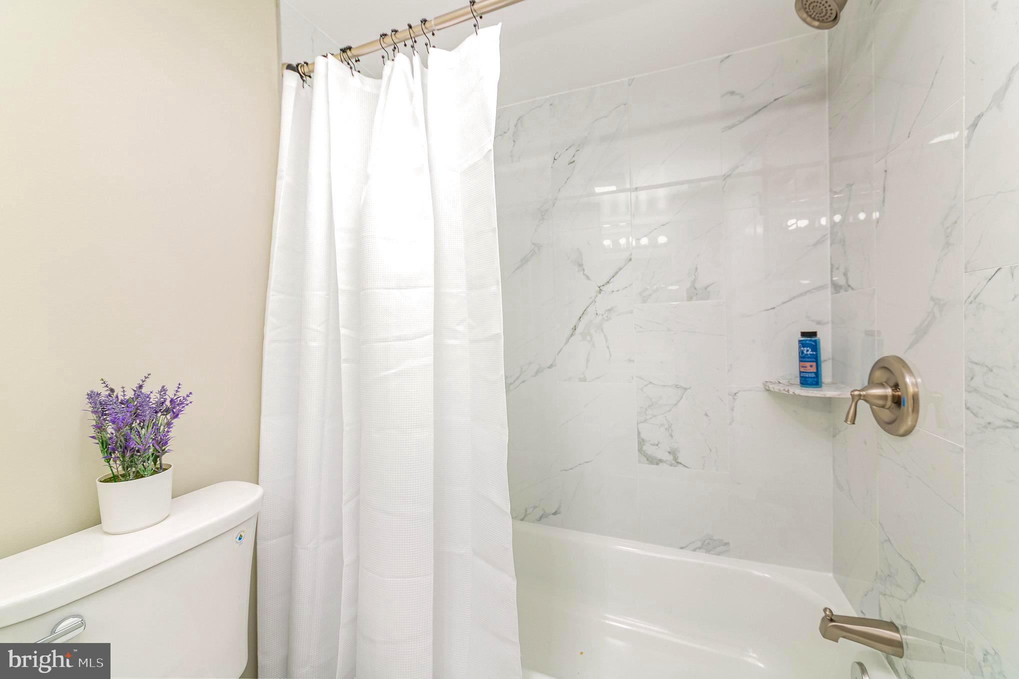 5611 Pilgrim Road Baltimore, MD 21214 - Photo 27 of 35 a bathroom with a shower curtain and a bathtub
