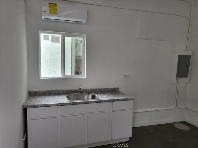 a bathroom with a granite countertop sink a mirror and shower