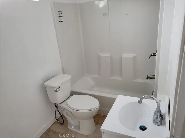 a white toilet sitting next to a bathroom sink